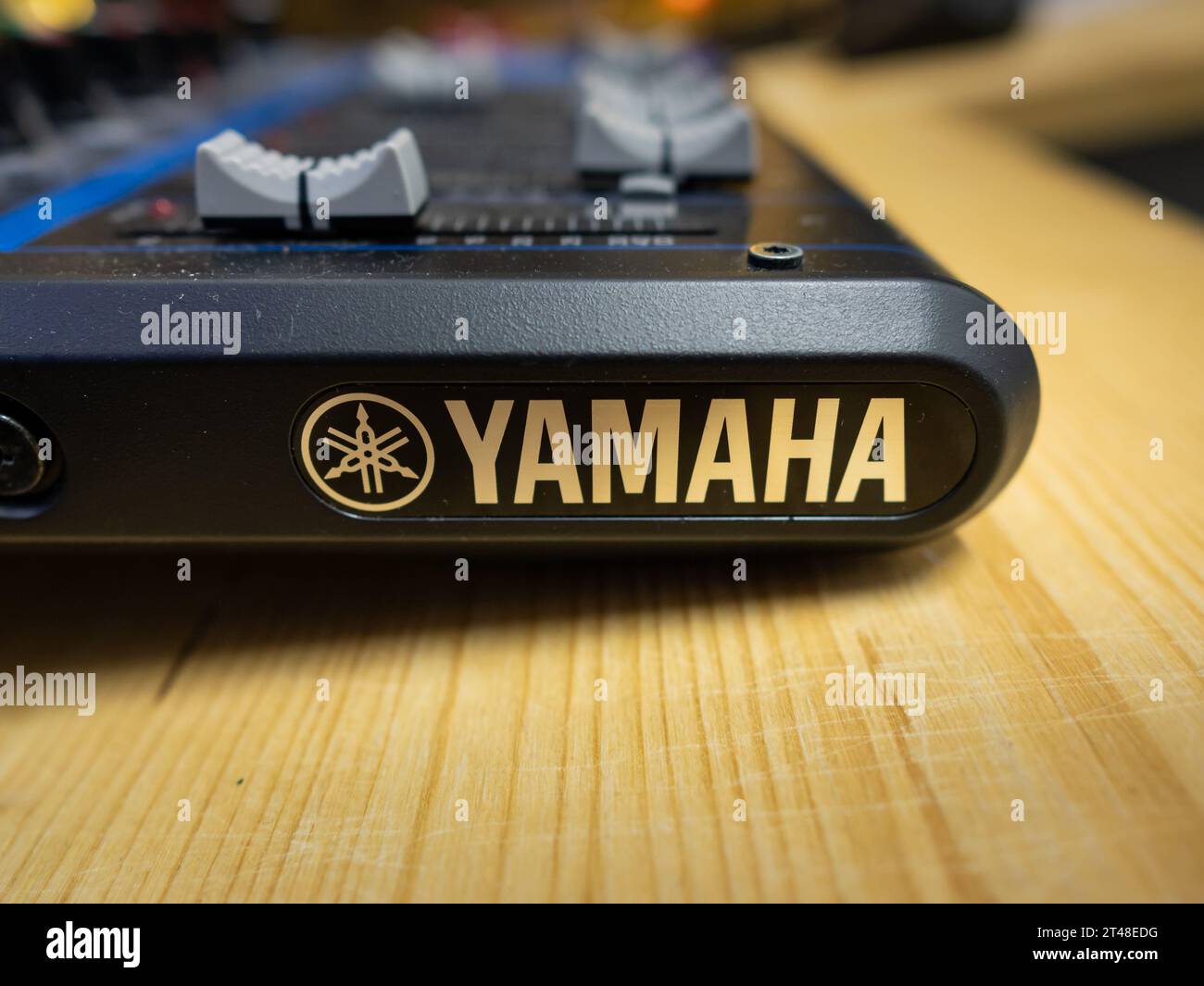 Yamaha-Logo auf einer kleinen Mischpultkonsole. Audiogeräte auf einem Holztisch. Technologie zum Einfügen und Kombinieren mehrerer Klangquellen für einen Ausgang. Stockfoto