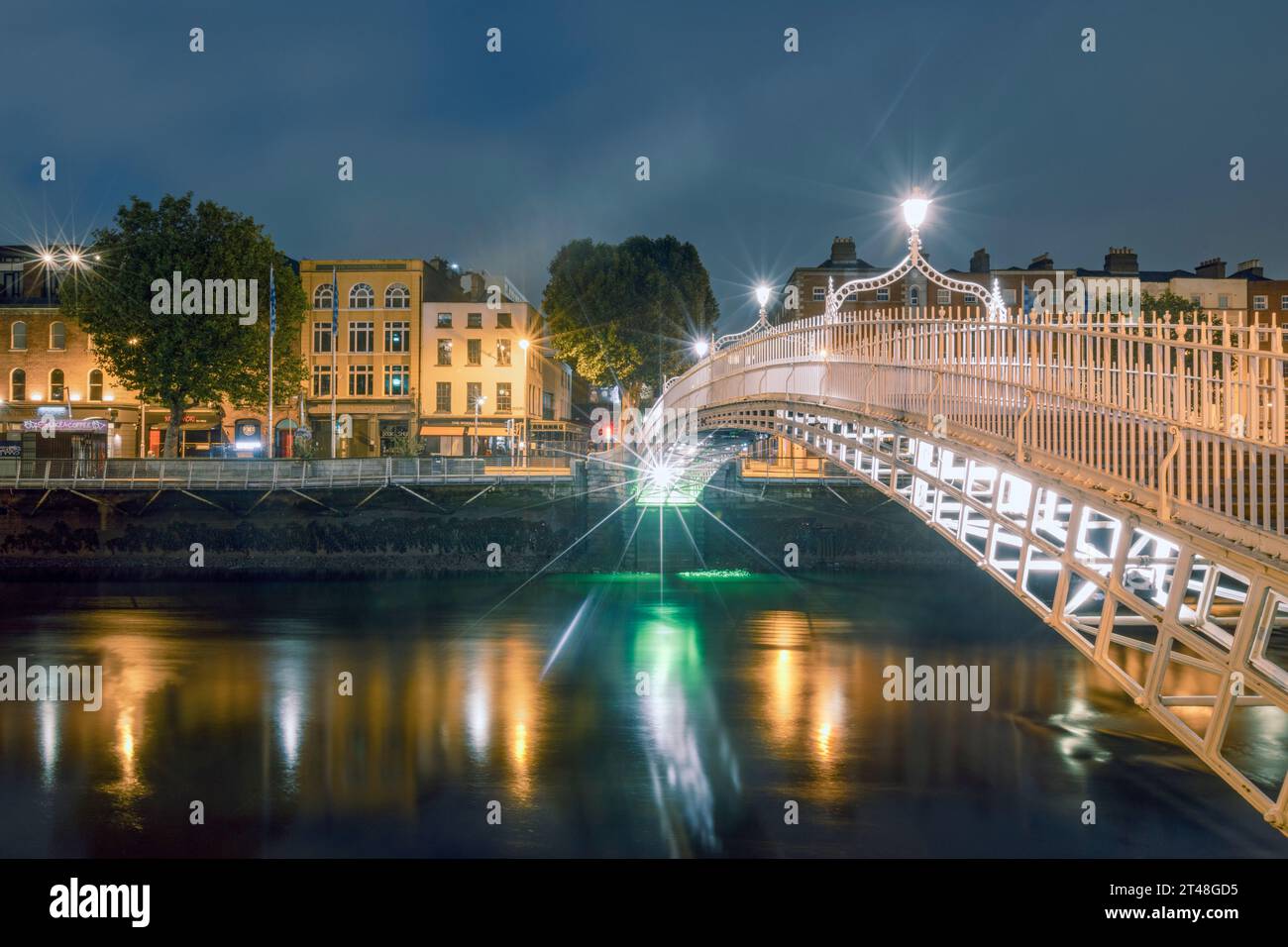 Die ha'Penny Bridge ist eine Fußgängerbrücke über den Fluss Liffey in Dublin, Irland, die für ihr schönes gusseisernes Design und ihren ikonischen Status bekannt ist. Stockfoto