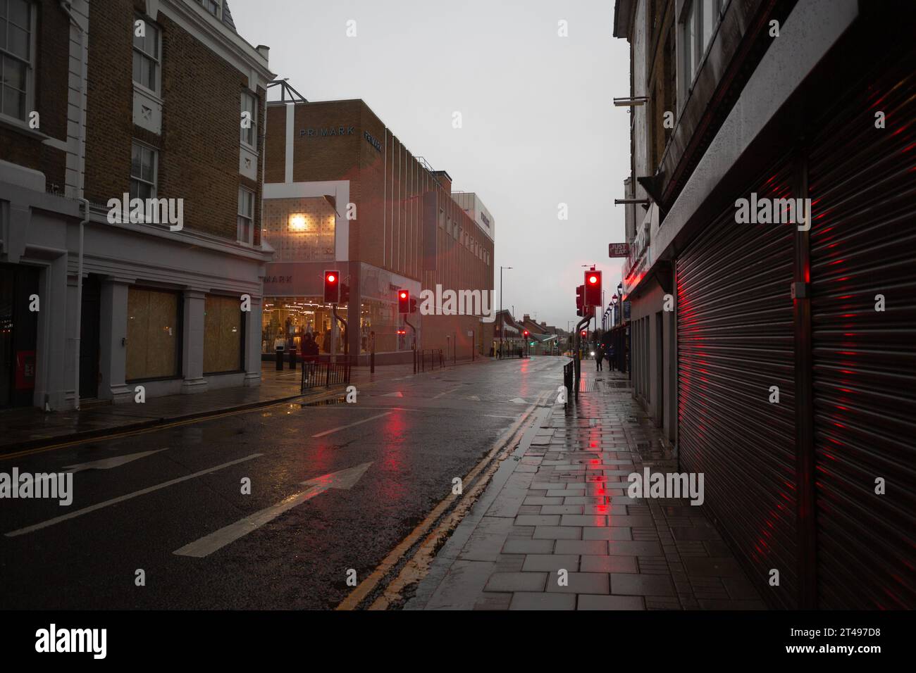 Dunkle Moody Street, die an einem frühen Herbstmorgen in Großbritannien in Richtung der Ampel blickt. Stockfoto