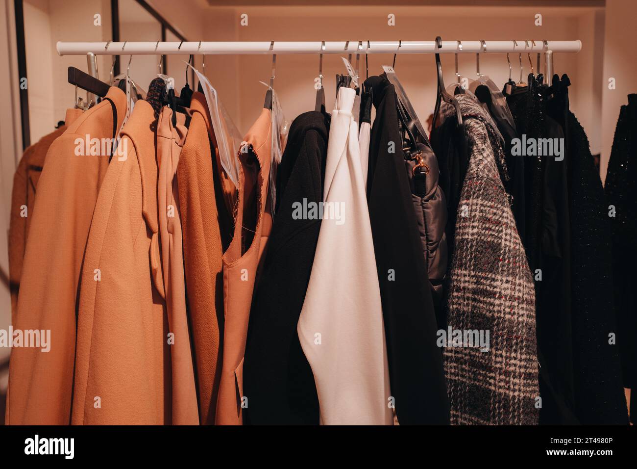 Herbstliche Designer-Outfits hängen hintereinander an der Backstage. Stockfoto