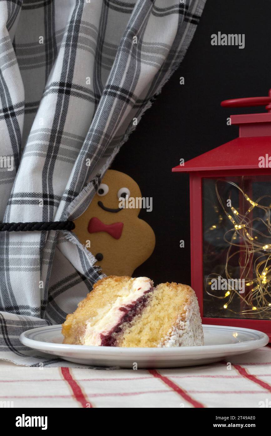 Frecher Ginger Biscuit Mann, der ein Stück Sahne-Kuchen mit Freude und Begehrlichkeit ansieht Stockfoto