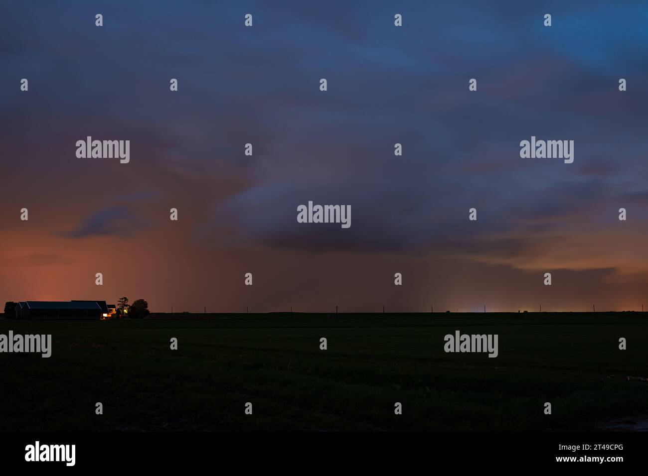 Donnernde Dusche über dem Ackerland im Abendlicht Stockfoto