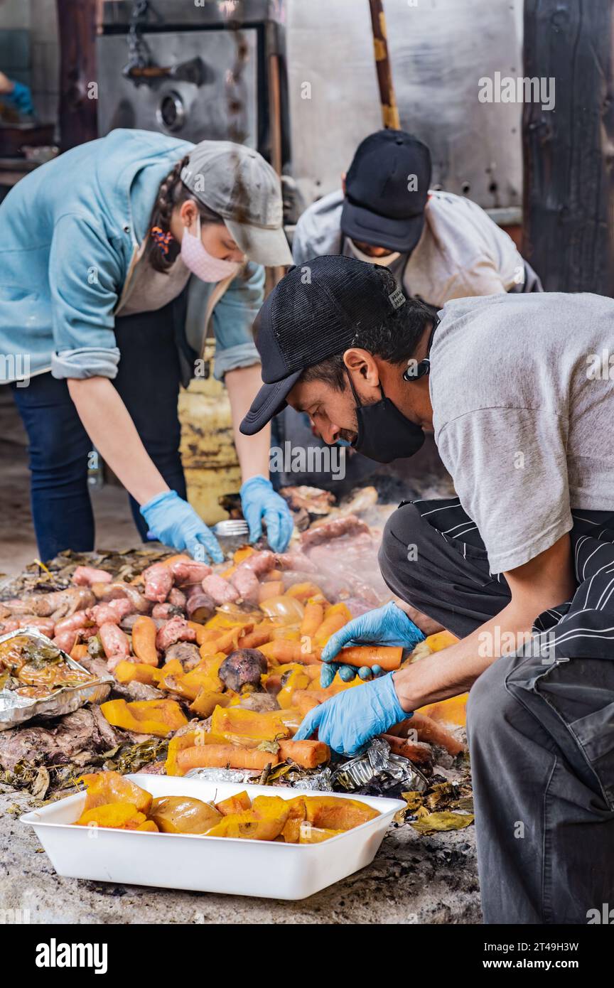 COLONIA SUIZA, SAN CARLOS DE BARILOCHE, ARGENTINIEN - 10. NOVEMBER 2021: Eine Gruppe von Köchen legte das Fleisch und Gemüse, das unterirdisch als Papa zubereitet wurde, beiseite Stockfoto