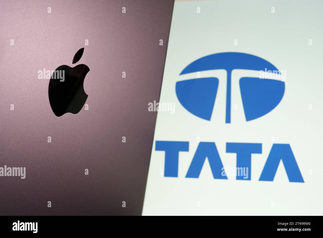 Apple-Logo auf dem iPad und verschwommenes Tata Group-Logo auf dem Laptop-Bildschirm. Tata beginnt mit der Herstellung von iPhones in Indien. Stafford, Großbritannien, Okt. Stockfoto