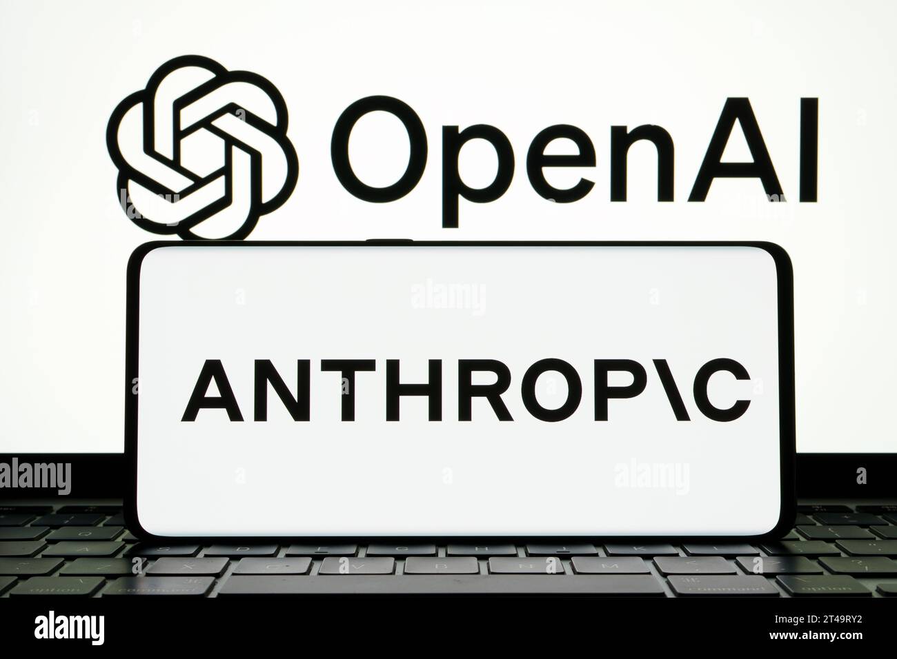 Das anthropische KI-Forschungsunternehmen Logo auf dem Smartphone und DAS OPENAI-Logo auf dem Hintergrund. Stafford, Vereinigtes Königreich, 29. Oktober 2023 Stockfoto