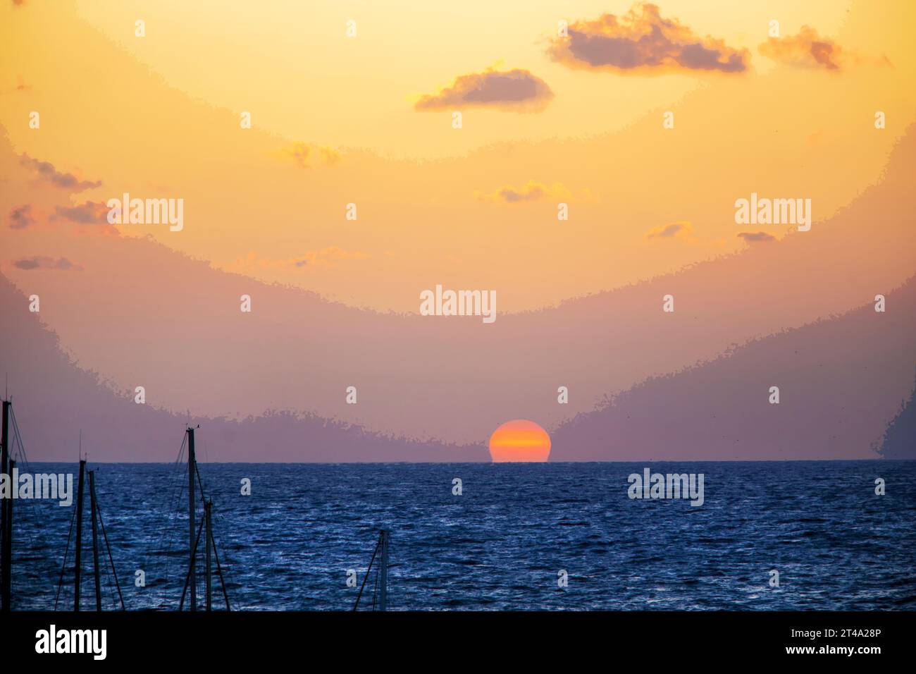 Fantastischer Sonnenuntergang - riesiger Sonnenuntergang im Mittelmeer. Rosa Himmel und Masten. Thema der Weihnachtsferien (Winterferien) in warm Stockfoto