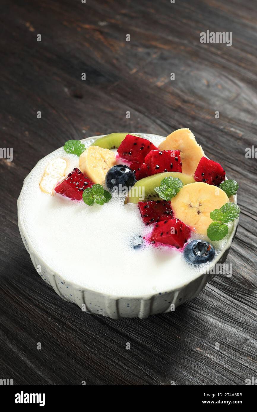 Joghurt mit frischem Obst, Drachenfrucht, Banane, Kiwi und Heidelbeere. Stockfoto