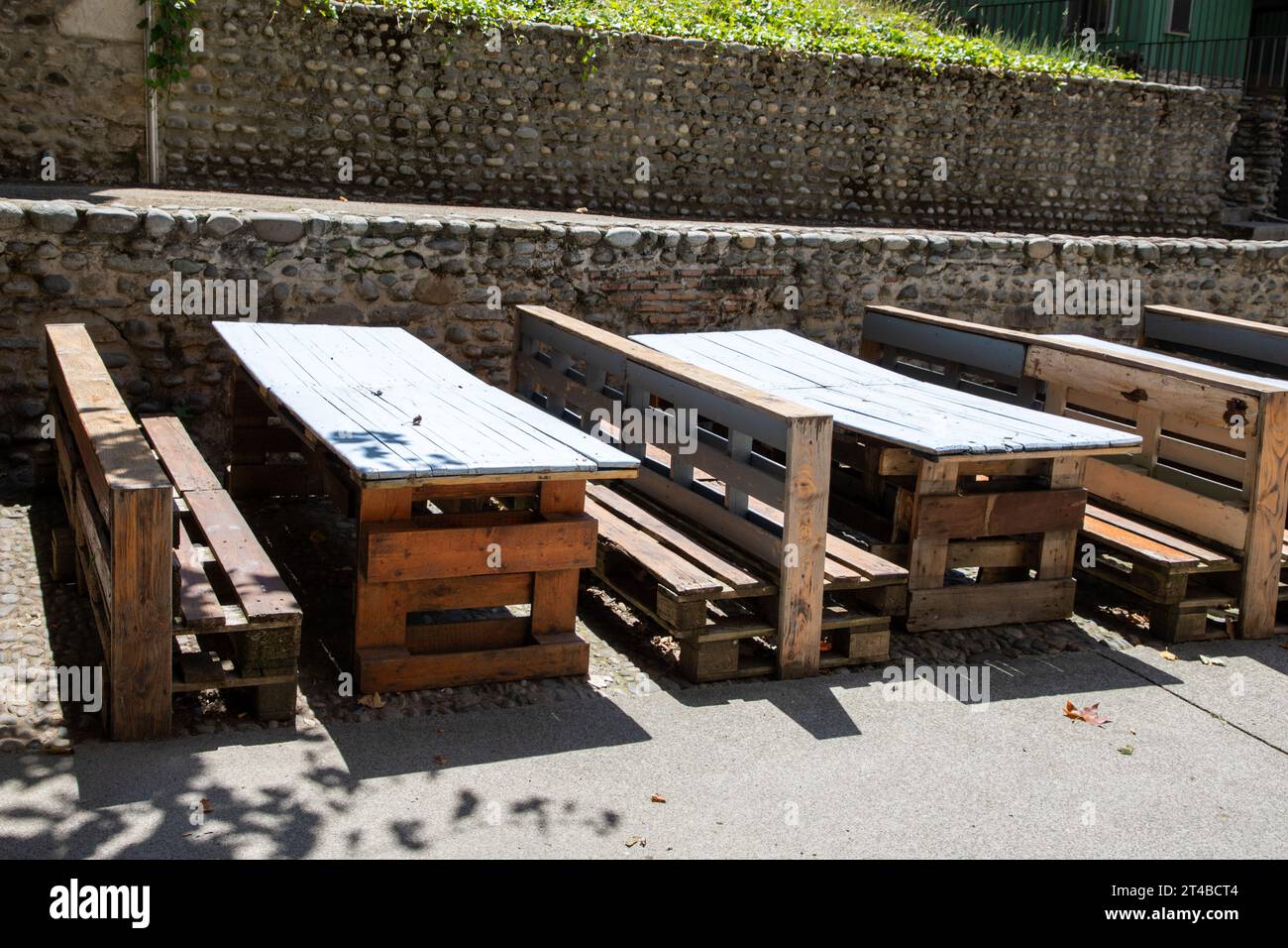 Tisch und Sitzbank aus recyceltem Holz aus alten recycelten Palettenplanken, die auf der Terrasse des Bar-Restaurants gebaut wurden Stockfoto