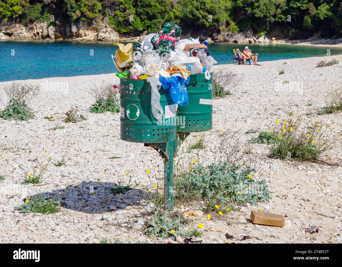 Überfüllte Mülltonnen an einem sauberen Strand an der Nordostküste von Korfu Griechenland Stockfoto