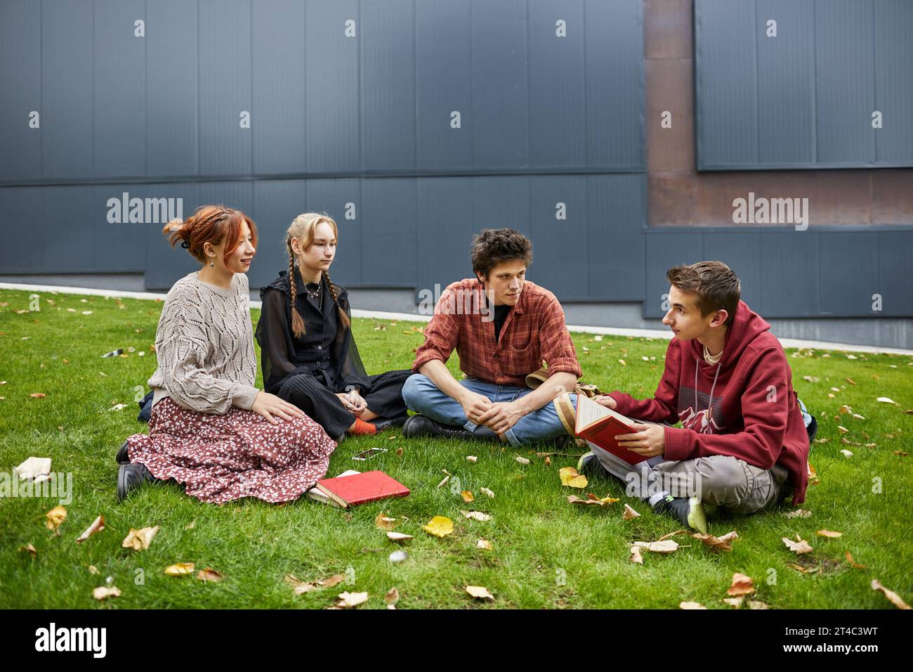 Studenten, die ein Buch im Campus-Hof lesen Stockfoto