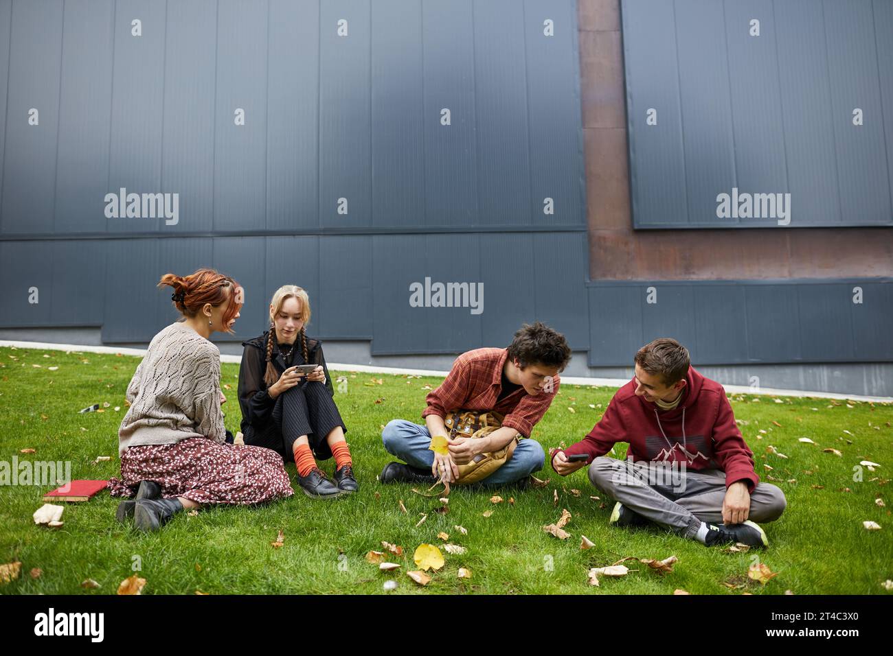 Schüler teilen sich Smartphones mit Freunden auf dem Campus Stockfoto