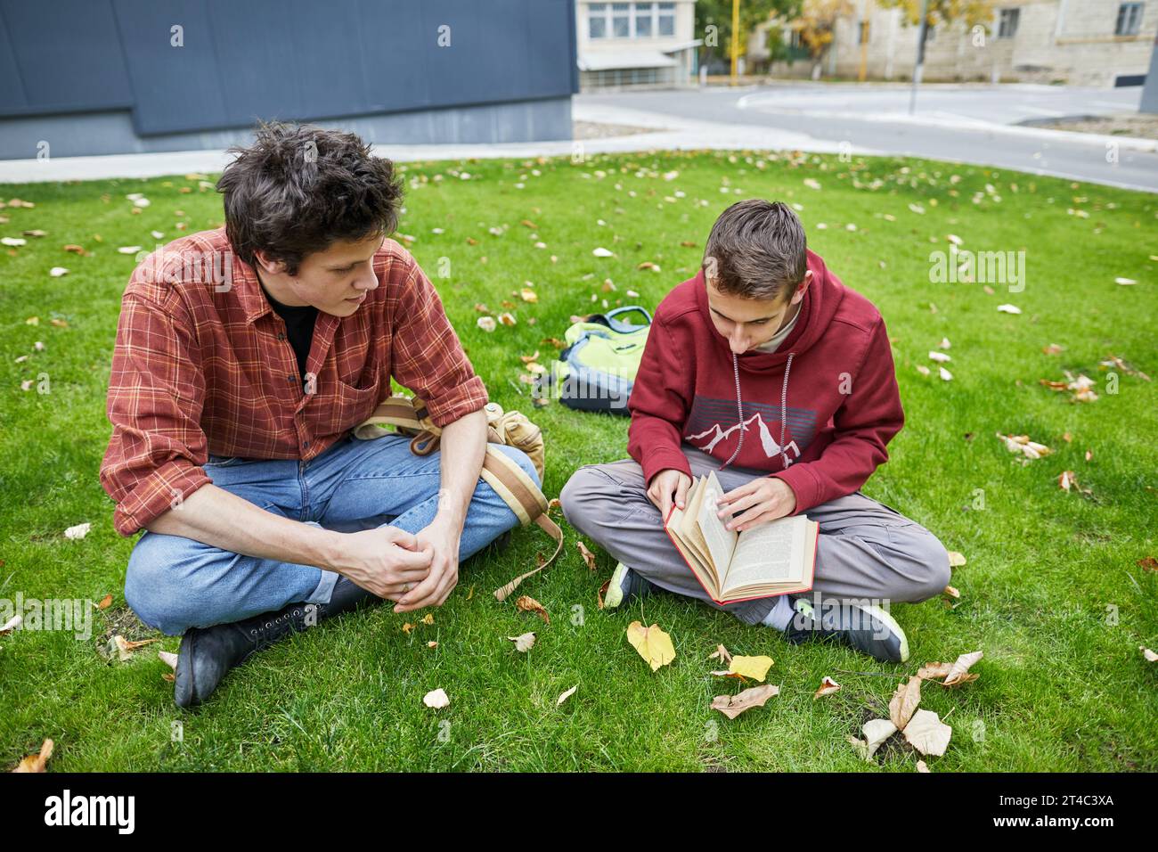 Typen, die sich ein Buch im Schulhof anschauen Stockfoto