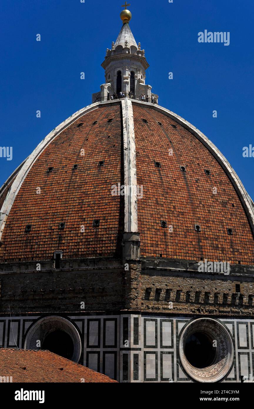 Zwei der acht „Segel“ oder Pendentive der Kuppel der Kathedrale von Florenz in der Toskana, Italien, gekrönt von einem weißen Marmorturm mit Aussichtsplattform am Fuß des Turms. Die achteckige Kuppel ist mit Terrakottafliesen bedeckt, die von acht Rippen aus weißem Marmor gekennzeichnet sind. Stockfoto