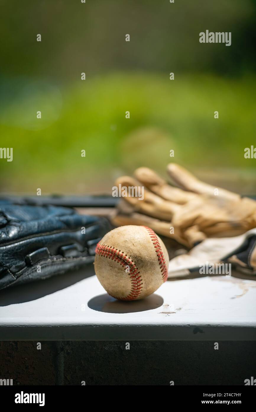 Der alte Baseballball, Handschuh und Schlaghandschuhe sitzen auf der schmutzigen Fensterbank mit Kopierraum Stockfoto