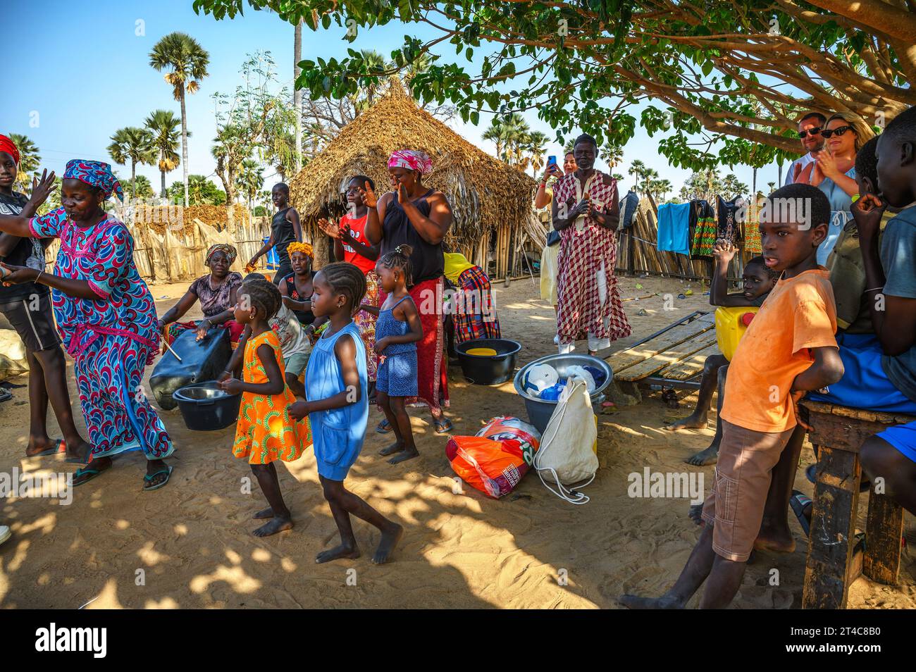 Afrikanische Schwarze tanzen vor Dorfhäusern in Senegal, Afrika Stockfoto