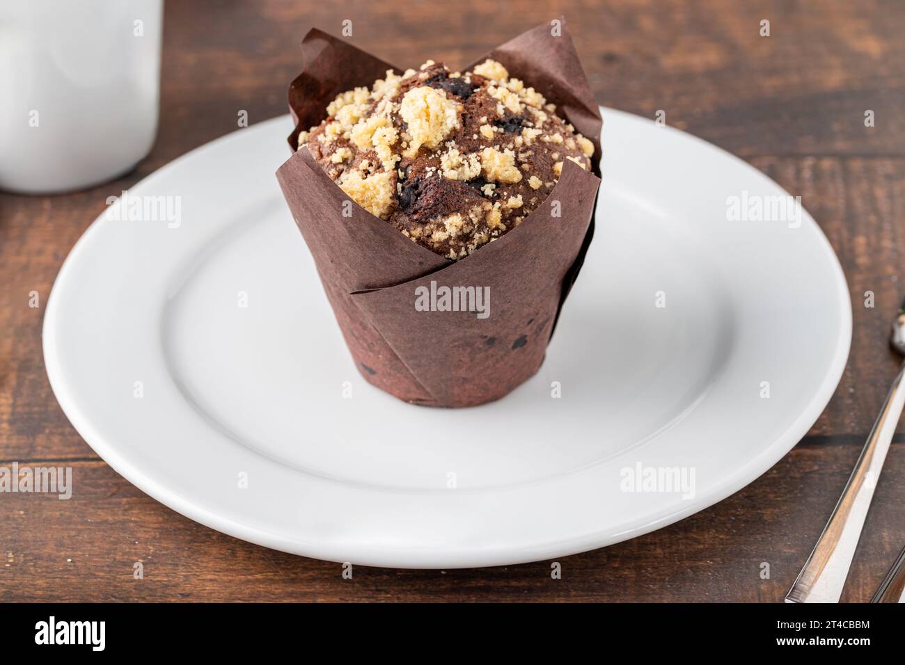 Schokoladenmuffin oder Cupcake mit Kaffee auf Holztisch Stockfoto