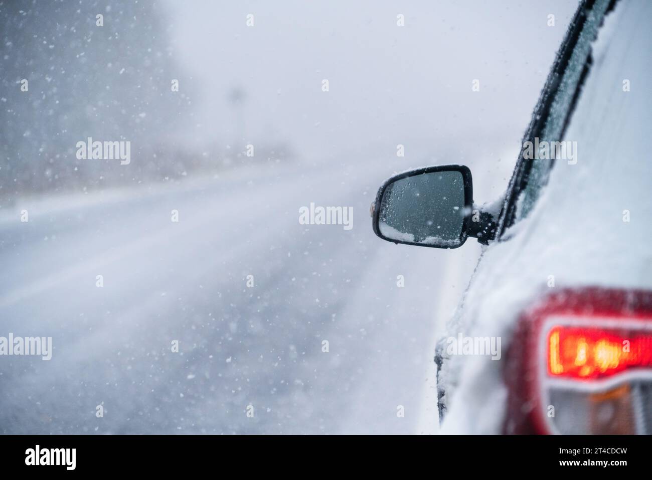 Das Auto fährt auf einer Winterstraße in einem Schneesturm. Stockfoto