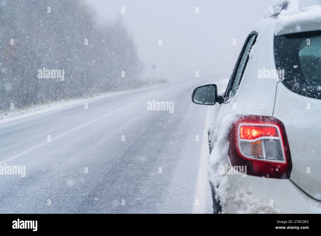 Das Auto fährt auf einer Winterstraße in einem Schneesturm. Stockfoto