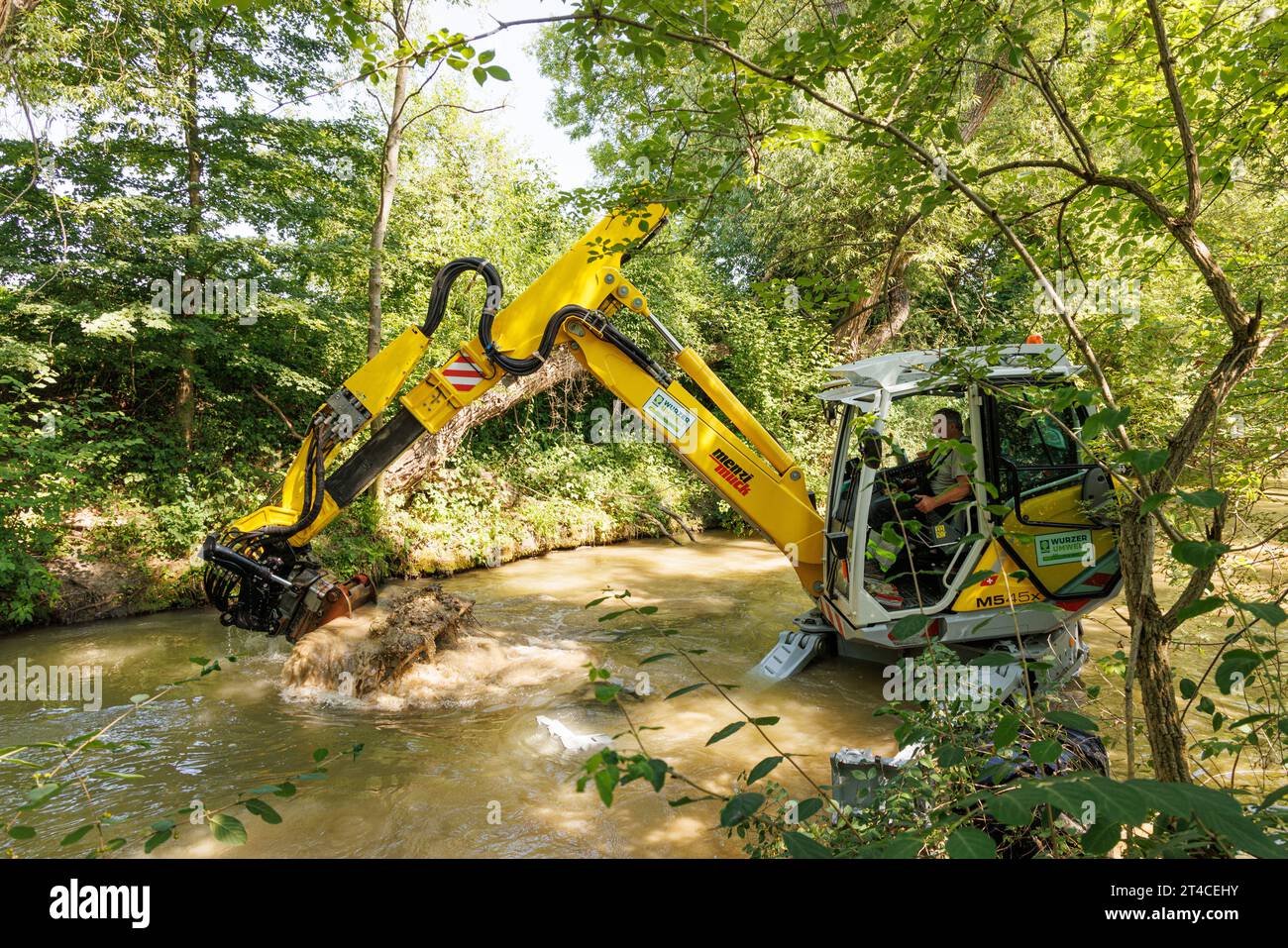 Bagger im Fluss löst Schlamm-Kies und schafft Laichplätze für Salmoniden, Renaturierung eines Wasserlaufs, Deutschland, Bayern, Dorfen Stockfoto