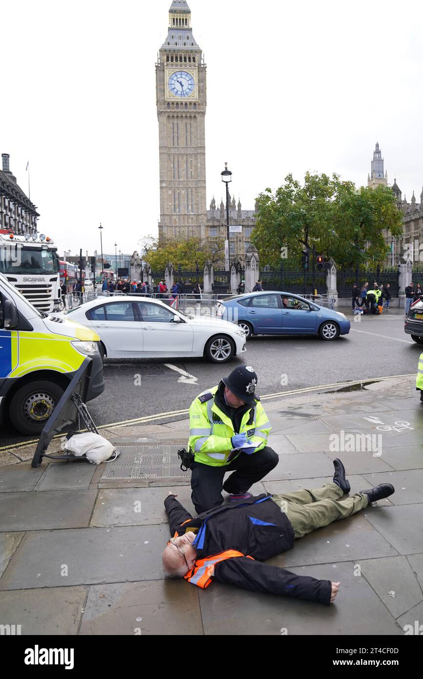 Just Stop Oil-Aktivisten demonstrieren auf dem Parliament Square, Westminster, Zentral-London, um von der Regierung zu fordern, alle neuen Öl-, Gas- und Kohleprojekte in Großbritannien sofort einzustellen. Bilddatum: Montag, 30. Oktober 2023. Stockfoto