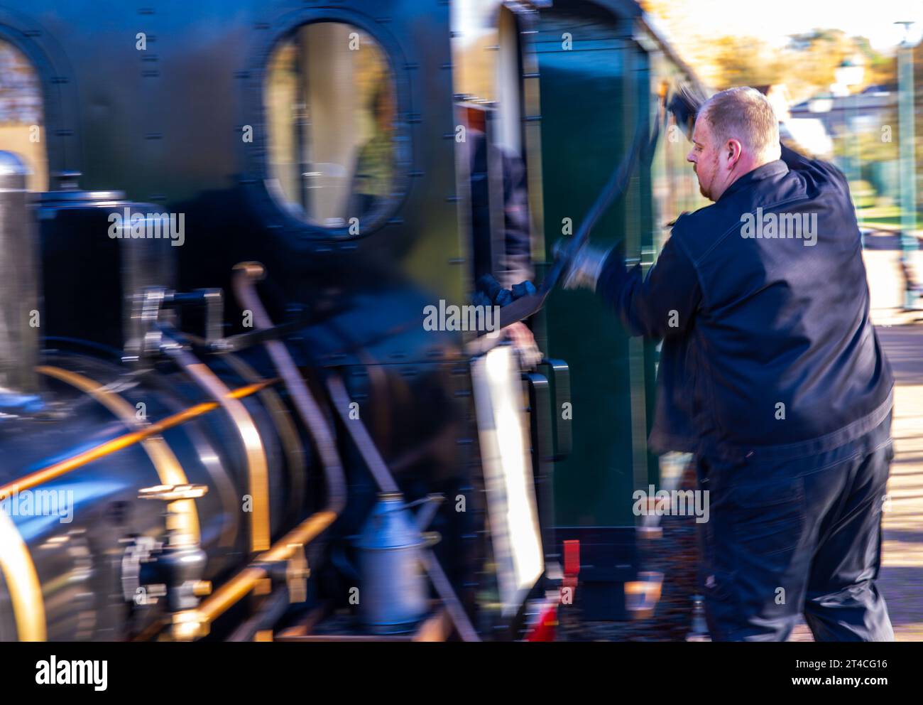 30. Oktober 2023, Mecklenburg-Vorpommern, Klütz: Stoker Lukas Münch schaufelt Kohle in die kleine 20-PS-Dampflokomotive, die 1921 von Orenstein & Koppel gebaut wurde. Die Lokomotive zieht einen Personenzug entlang der Schmalspurbahn Kaffeebrenner. Am Ende der Saison wird die Strecke auf der Touristenbahn mit einer Spurweite von 600 Millimetern von einem historischen Dampfross angetrieben. Foto: Jens Büttner/dpa Stockfoto