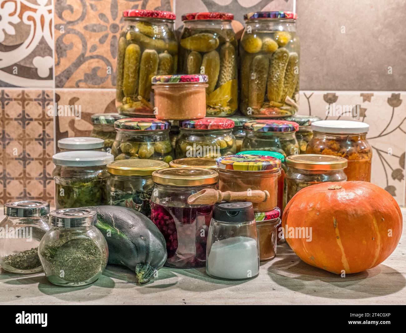 Verschiedene Obst- und Gemüsekonserven in Gläsern auf Küchentisch Stockfoto