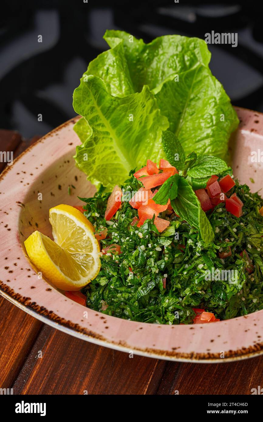 Nahaufnahme syrischer Tabbouleh mit Salat, Petersilie, Tomate und Zitrone Stockfoto