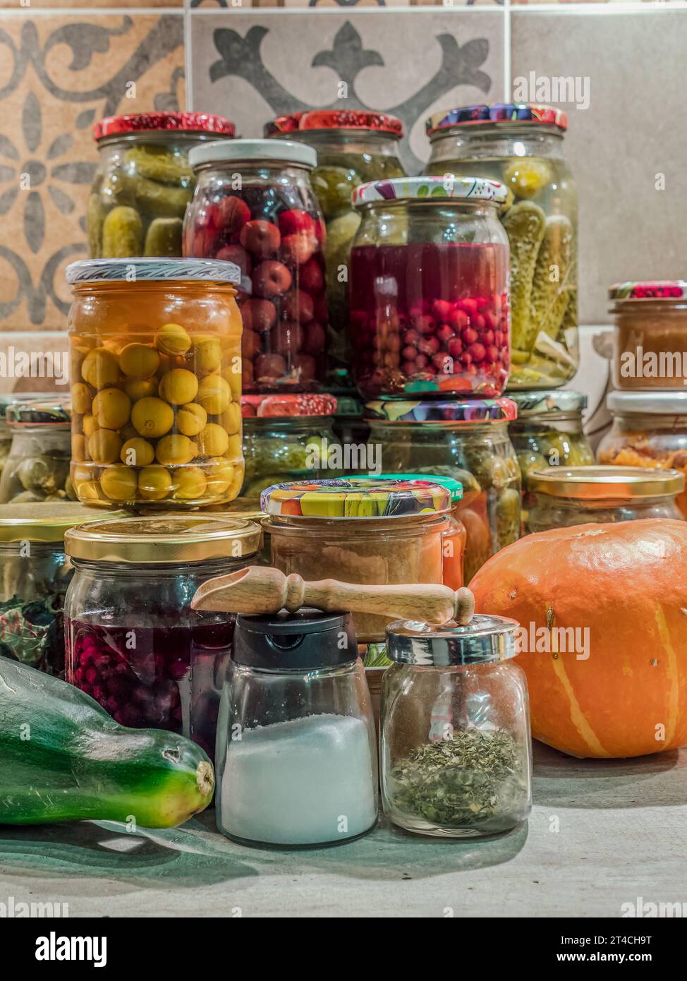 Verschiedene Obst- und Gemüsekonserven in Gläsern auf Küchentisch Stockfoto