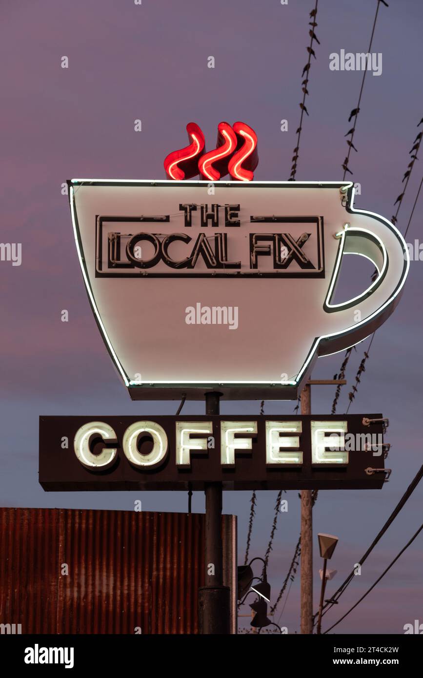 Neonzeichen einer Kaffeetasse mit Dampf, die für ein Café namens The Local Fix, Early Morning, Uvalde, Texas, USA, austritt. Stockfoto