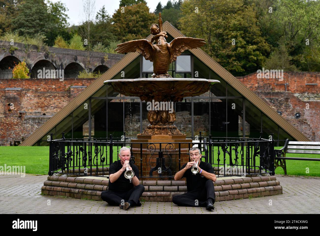 Mitglieder der Jackfield Band und der Boy and Swan gusseiserne Wasserbrunnen im Coalbrookdale Museum of Iron. Hier findet das Brass Band Festival statt Stockfoto