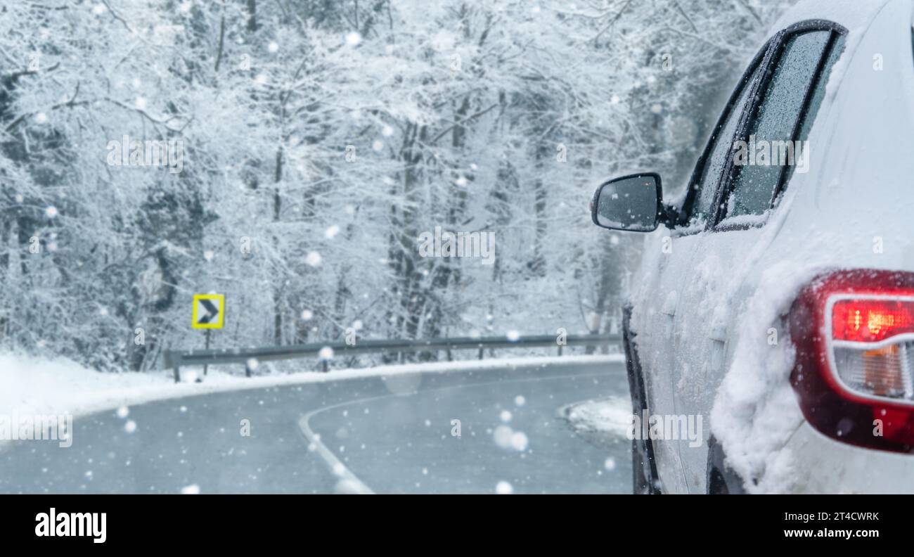 Das Auto fährt auf einer Winterstraße in einem Schneesturm. Stockfoto