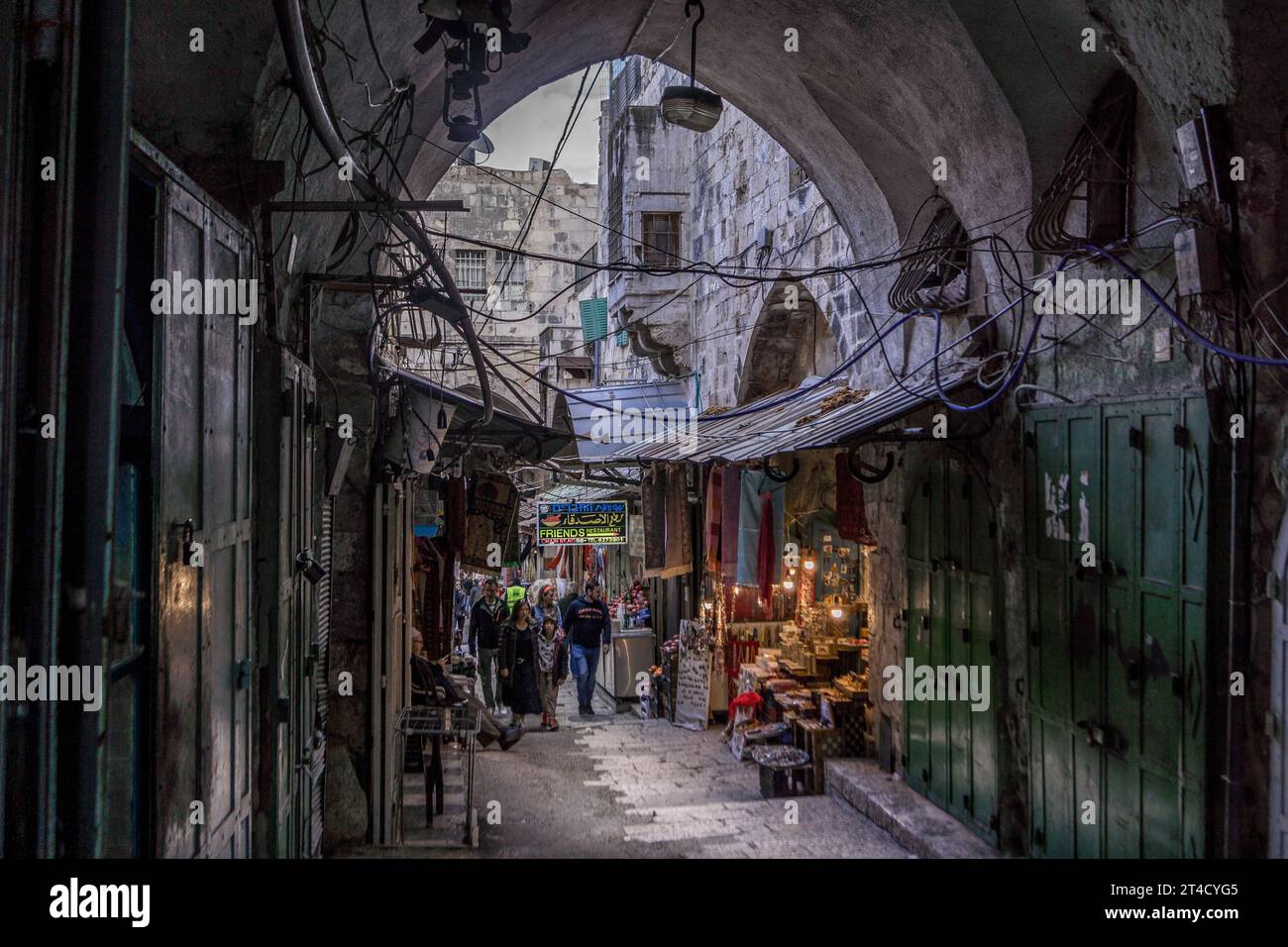 Der Jerusalemer Altstadtmarkt mit Souvenirläden, Geschäften und Touristen, die durch die Basarallee im muslimischen Viertel gehen. Stockfoto