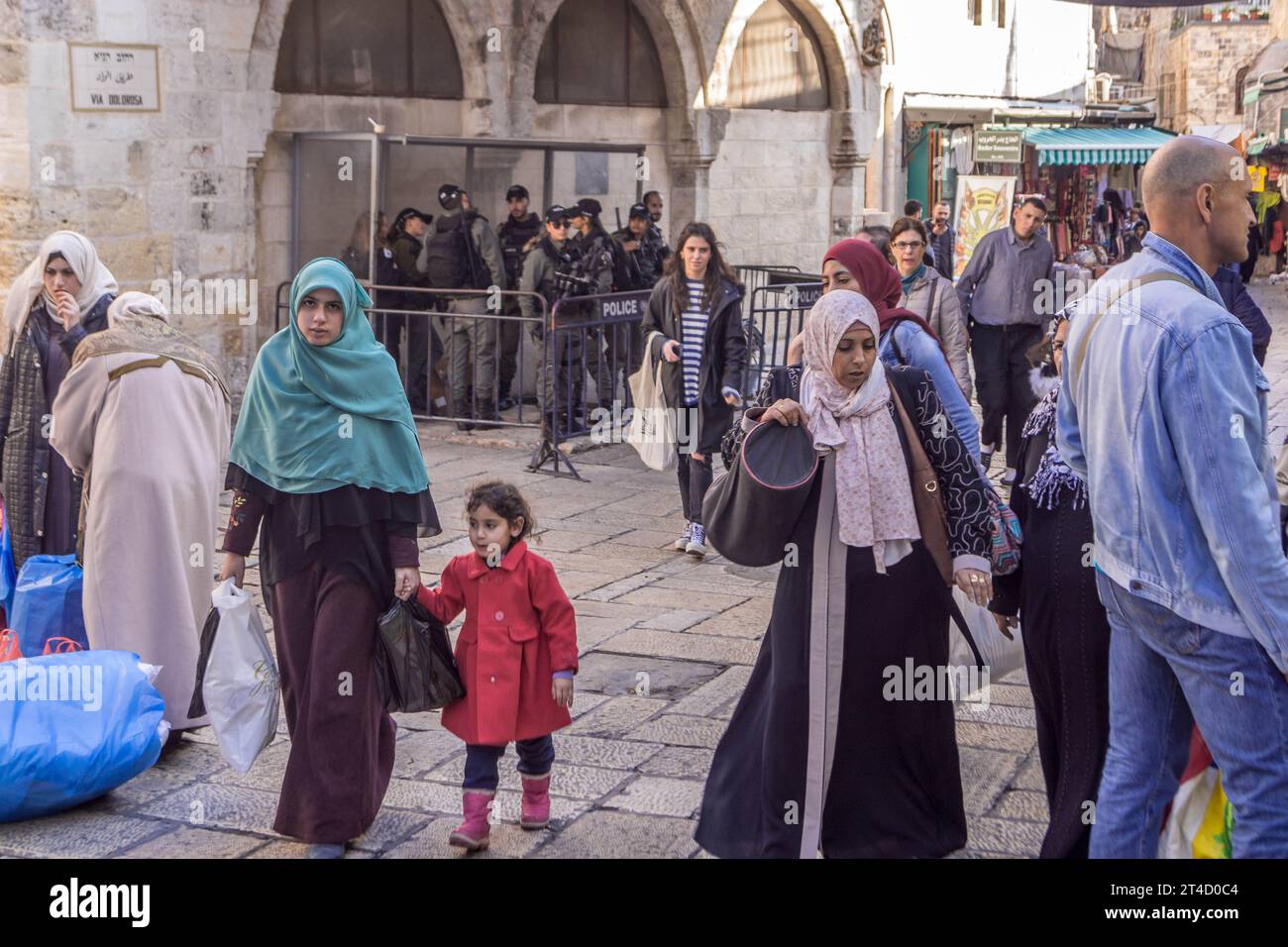 Die Einheimischen, verschleierte muslimische Frauen, jüdische Leute, Touristen vor dem gepanzerten Polizeikontrollpunkt in der Via Dolorosa, Jerusalem Altstadt, Israel. Stockfoto