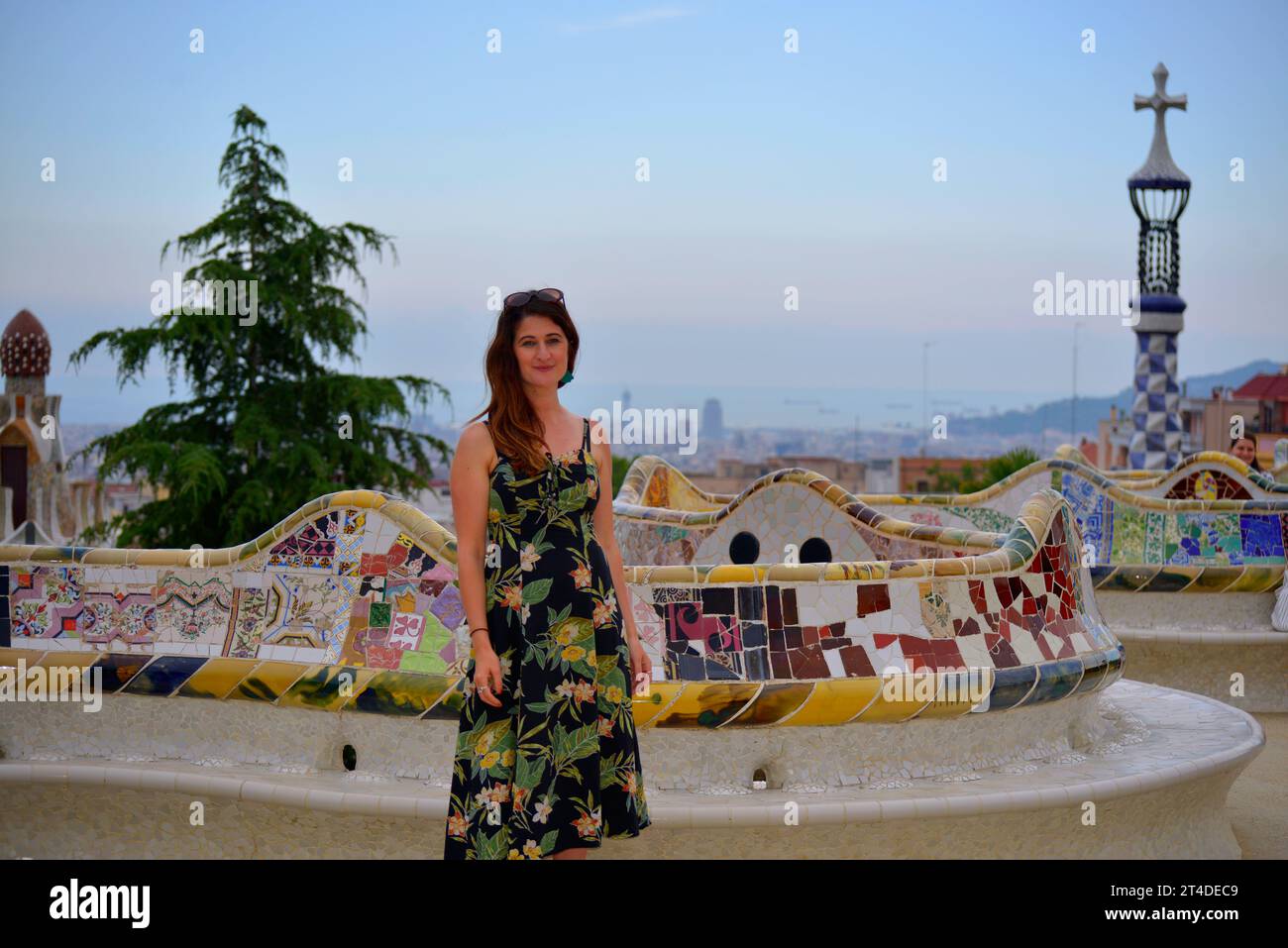 Ein lächelndes Touristenmädchen besucht den Park Güell des Architekten Antoni Gaudí in Barcelona, Spanien Stockfoto