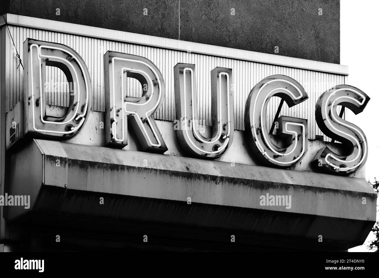 Bronx NY - 28. Oktober 2023: Schwarz-weißes Retro-Neon-Schild „Drugs“ in der Pilgrim Pharmacy Drogerie in New York City Stockfoto