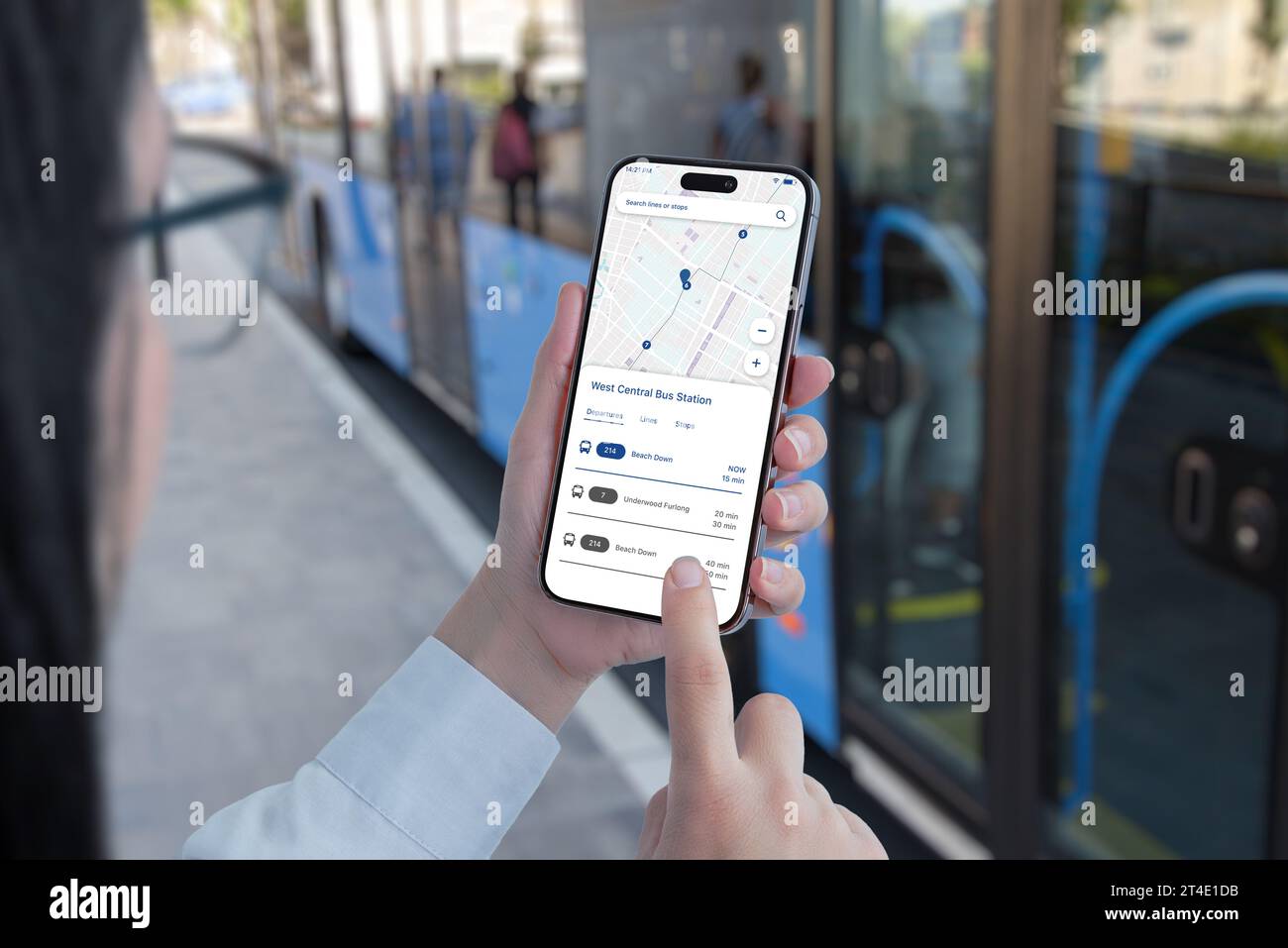Öffentliche Verkehrsmittel-App auf Smartphone in Frauenhänden Konzept. Bus am Bahnhof im Hintergrund Stockfoto