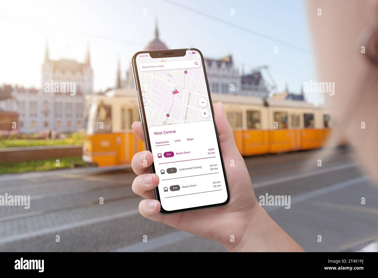 Trolleybus City Transport App auf Smartphone in Frauenhand. Trolleybus in der Stadt im Hintergrund Stockfoto