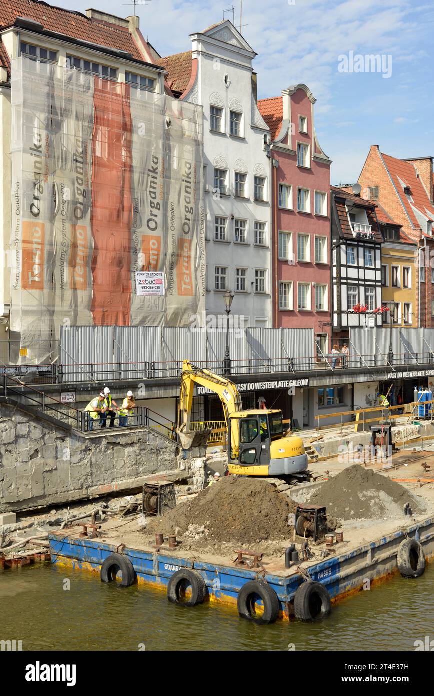 Renovierungsarbeiten und Baustelle mit Bagger auf schwimmender Plattform am Ufer des Motlawa-Flusses in der Altstadt von Danzig, Polen, Europa Stockfoto