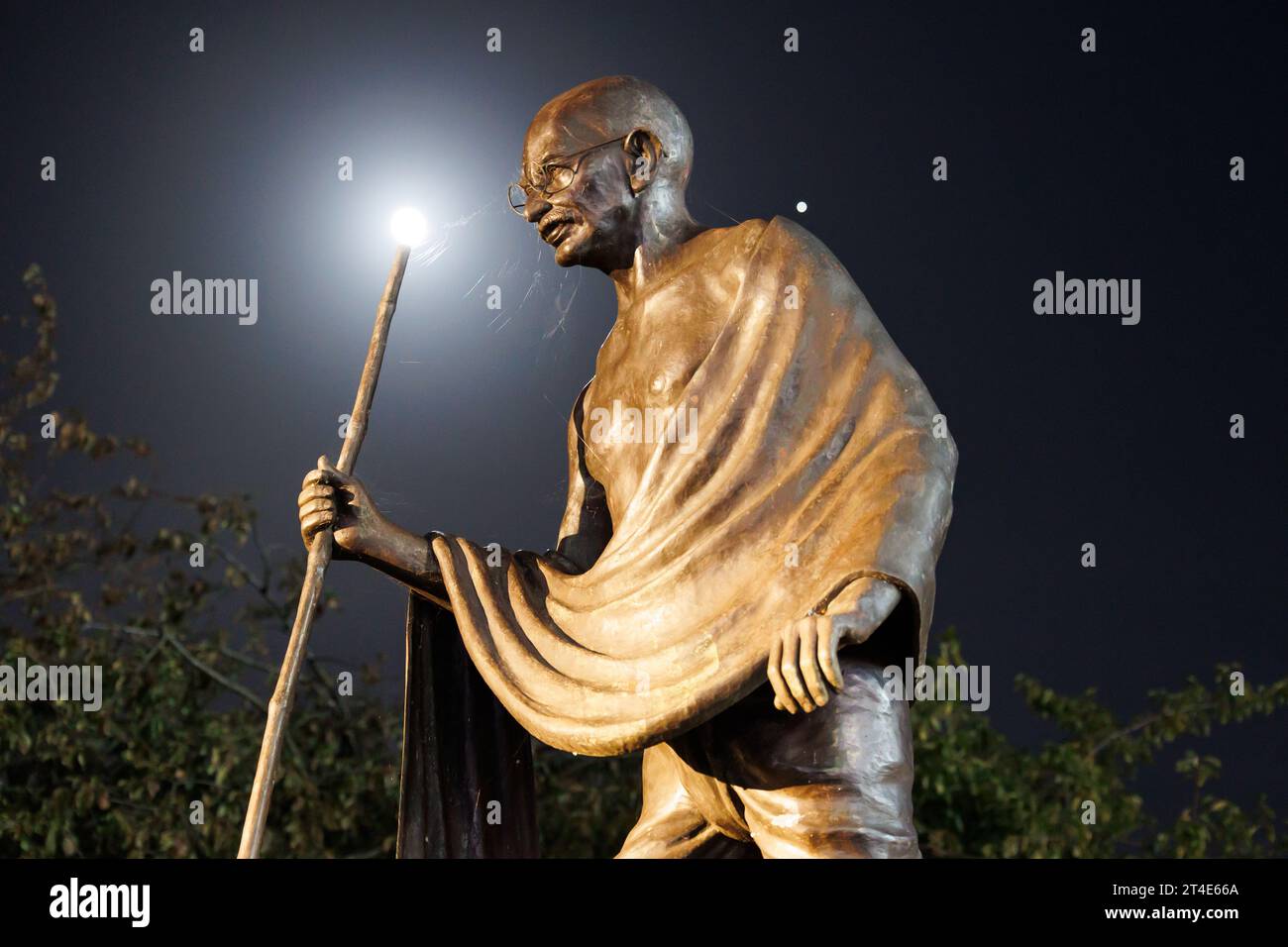 Die Statue von Mahatma Gandhi an der Belgrave Road, Leicester. Das Foto wurde nachts aufgenommen, während das Licht des Mondes auf der Statue leuchtete. Die Statue war Schauplatz von Protesten gegen die Entfernung der Statue. Die Statue befindet sich neben der Goldenen Meile, dem Bereich, in dem jedes Jahr die wichtigsten Diwali-Feierlichkeiten stattfinden. Stockfoto