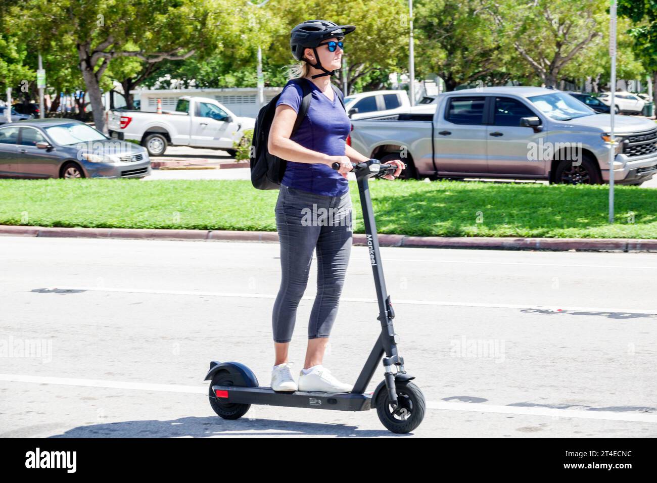 Miami Beach Florida, fahren elektrische Roller, tragen Sicherheitshelm Rucksack Straße, Frau Frauen weiblich, Erwachsene, Bewohner Stockfoto