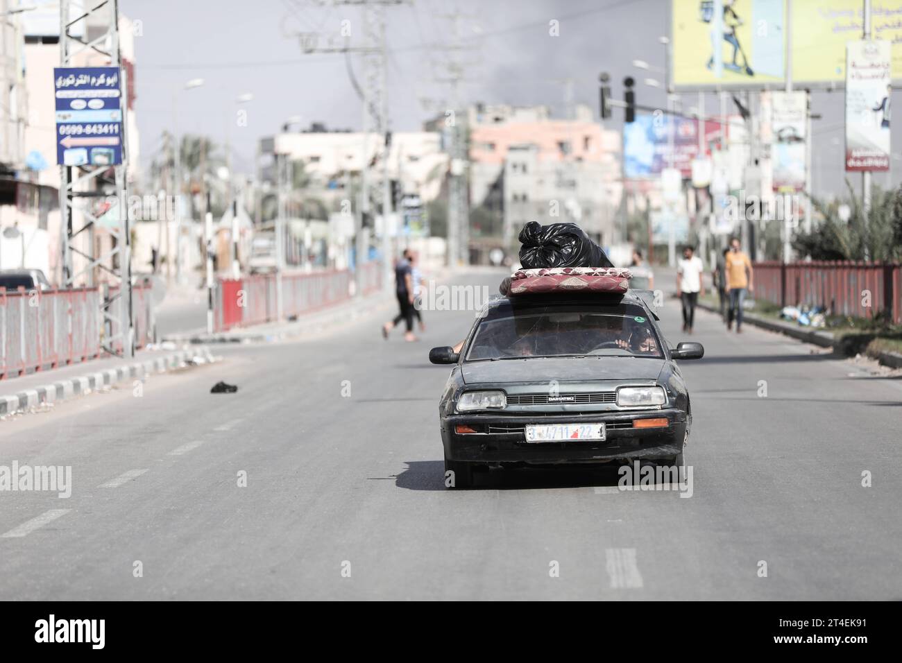 Palästinenser fahren ein Auto mit Habseligkeiten, während Rauch im Hintergrund aufsteigt, während sie aus dem Flüchtlingslager Nuseirat fliehen Palästinenser fahren ein Auto mit Habseligkeiten, während Rauch im Hintergrund auftaucht, während sie am 30. Oktober 2023 aus dem Flüchtlingslager Nuseirat im zentralen Gazastreifen fliehen. zwischen Israel und der palästinensischen Gruppe Hamas. Foto: Naaman Omar apaimages Nuseirat Gaza Streifen palästinensisches Gebiet 301023 Nuseirat NAA 0018 Copyright: XapaimagesxNaamanxOmarxxxapaimagesx Credit: Imago/Alamy Live News Stockfoto