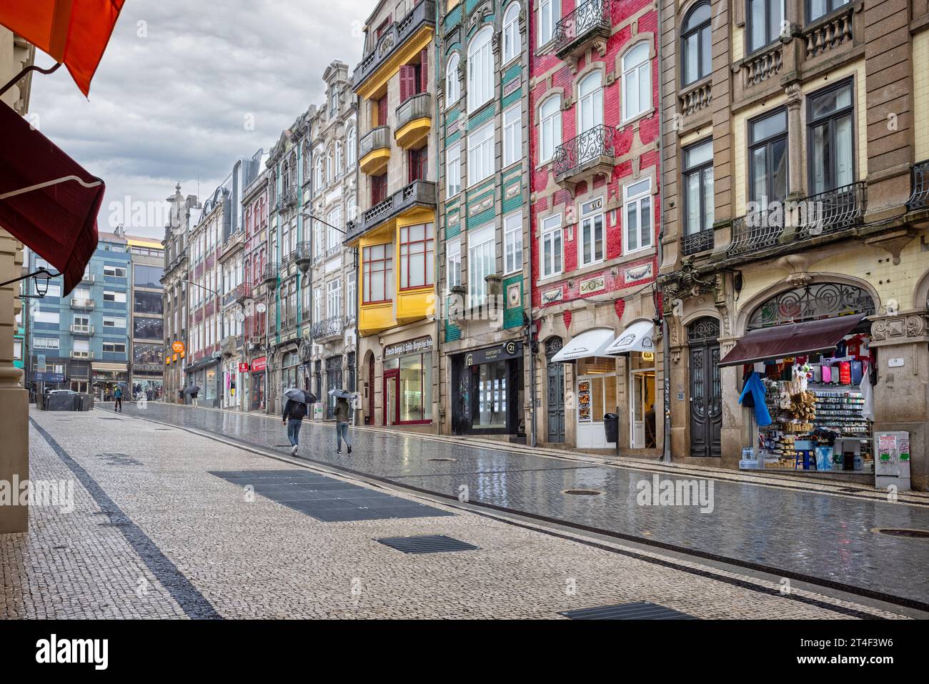 Am 19. Oktober 2023 spazieren Sie mit Regenschirmen in sintflutartigen Regenfällen auf der Alexander Braga Road neben dem Bolhao Markt in Porto, Portugal Stockfoto