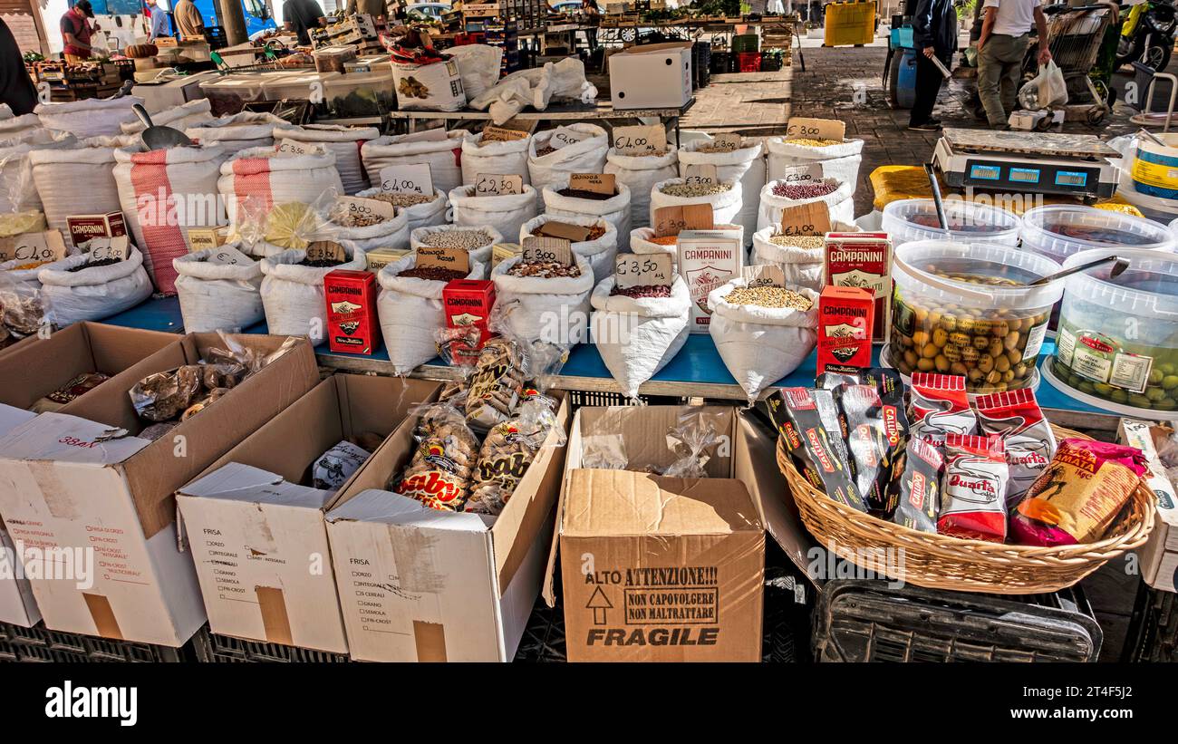 Ein Marktstand auf einem Bauernmarkt in Brindisi, Italien, der eine große Auswahl an Lebensmitteln wie Nüsse, Hülsen, Kaffee und Oliven verkauft. Stockfoto