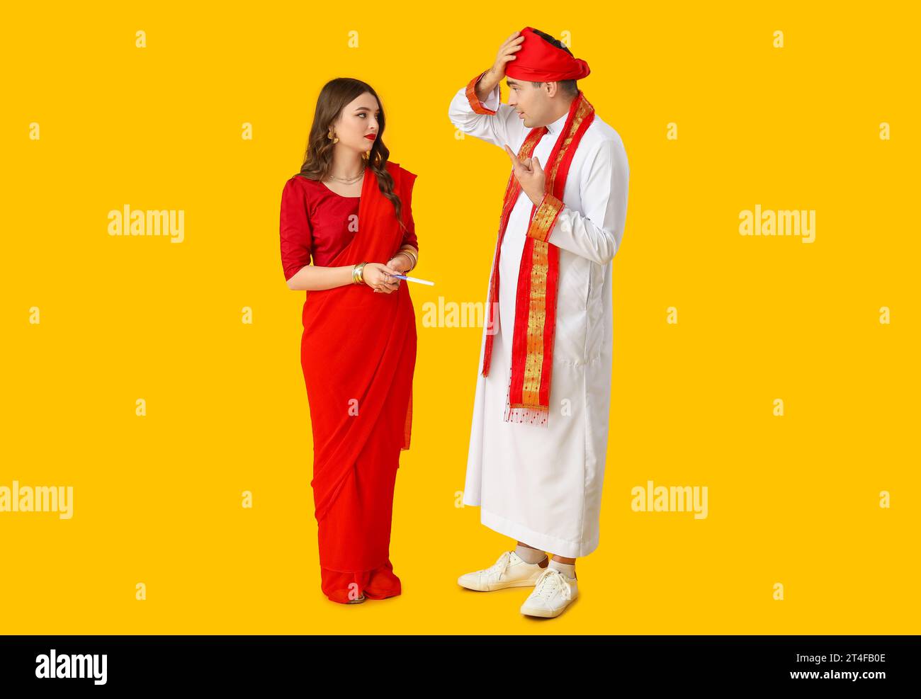 Verängstigte indische Paare mit Schwangerschaftstest auf gelbem Hintergrund Stockfoto