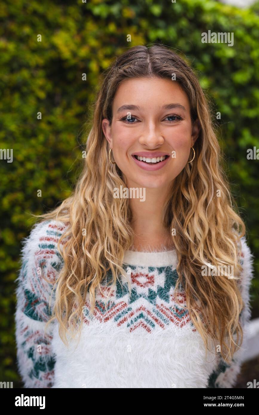 Porträt einer glücklichen kaukasierin mit langen blonden Haaren, die im Garten lächelt Stockfoto