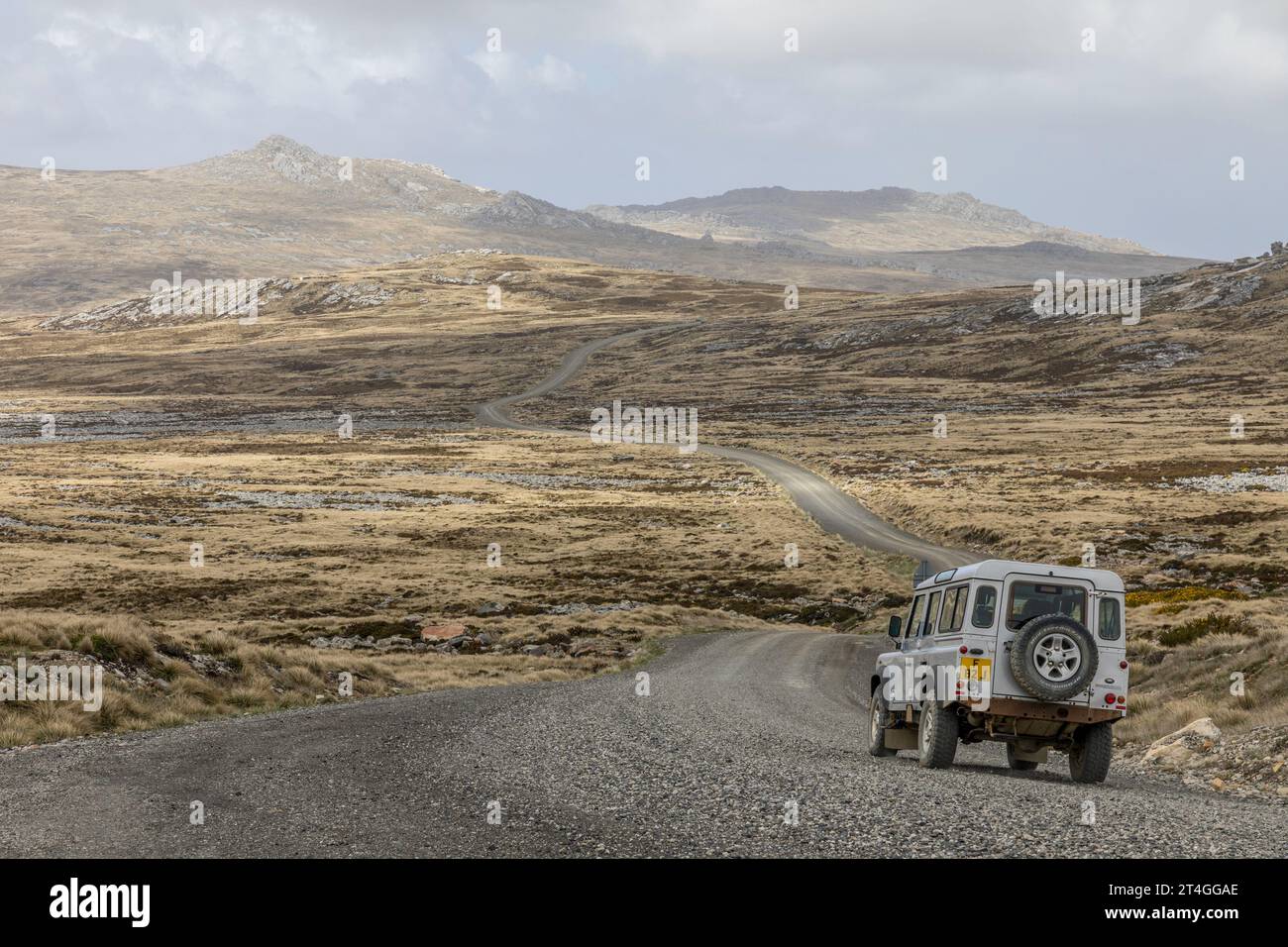 Ein Land Rover, der eine Schotterstraße entlang fährt, die Stanley mit dem Norden von East Falkland auf den Falklandinseln verbindet. Bekannt als Northern Camp Road. Stockfoto