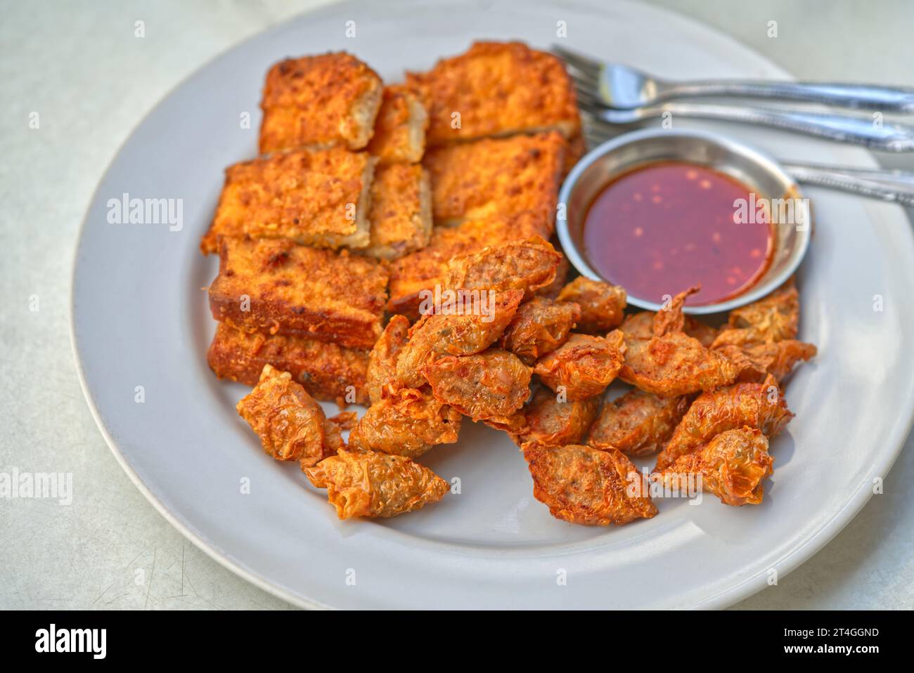 Thailändische Küche, frittierte Würstchen und frittiertes Schweinebrot mit süßer und scharfer Sauce. Nahaufnahme des traditionellen Frühstücks von Surat Thani Prov Stockfoto