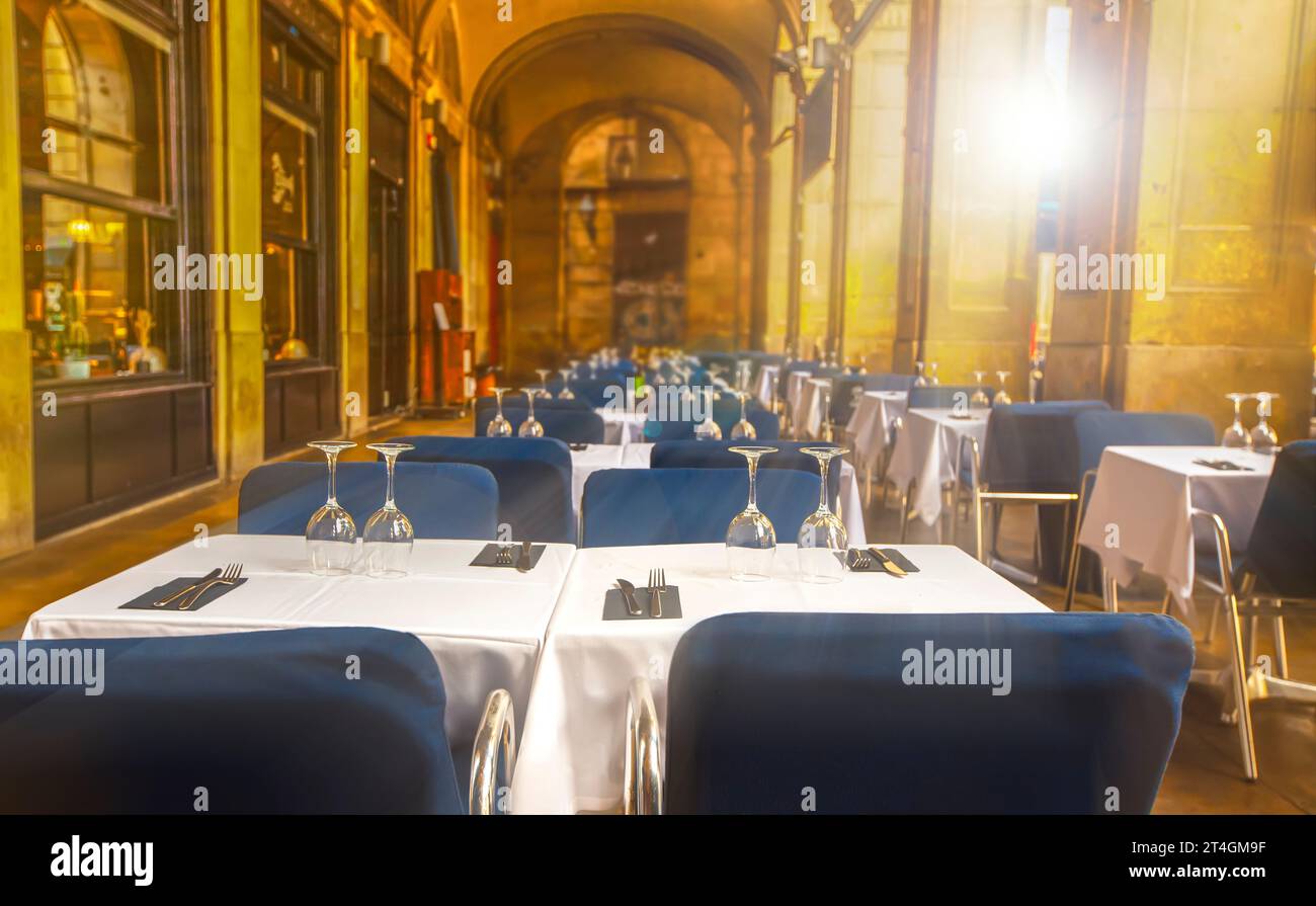 Das leere Straßencafé im Sommer mit überdachten weißen Tischen im Sonnenlicht Stockfoto