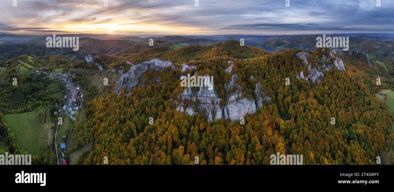 Berge bei Sonnenuntergang in der Slowakei - Vrsatec. Landschaft mit Berghügeln, Orangenbäumen und Gras im Herbst, farbenfroher Himmel von der Drohne, Aerial Panorama Stockfoto