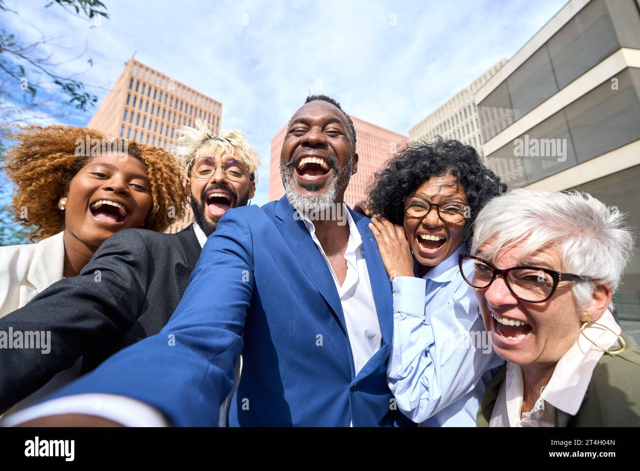 Glücklicher afrikanischer Geschäftsmann, der ein Selfie macht und mit multiethnischen Kollegen lacht Stockfoto